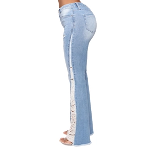 Detail view of light blue flared jeans featuring distressed ripped sides and raw hem design