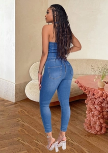 Detailed back view of a slim-fit denim halter jumpsuit with a long rear zipper
