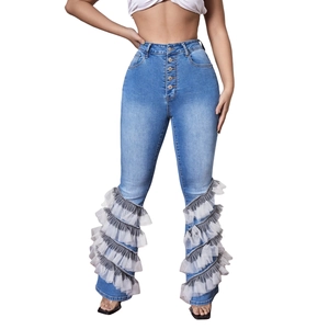 High-waisted blue jeans featuring multi-layer grey and white mesh ruffles at the hem