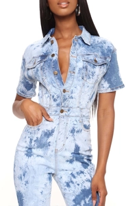 Detail of acid wash light blue denim jumpsuit featuring metal buttons and turn-down collar