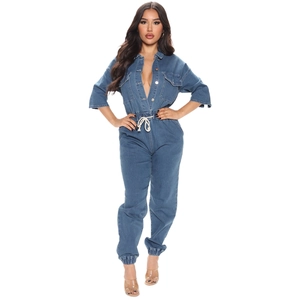 Women's denim jumpsuit with deep V-neck, utility pockets and drawstring waist in mid-blue
