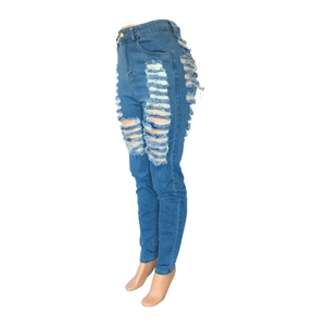 Détail du jean bleu taille haute avec déchirures prononcées et textures effilochées