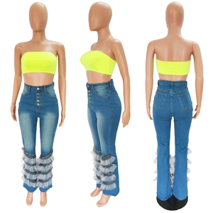 Detail showing high waist denim jeans with decorative buttons and mesh ruffle hem
