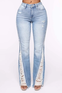 Detail of high waisted flare jeans with distressed vertical fringe and raw hem edges