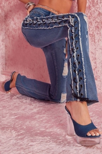 Detail of high-stretch flared jeans with lace-up eyelets and distressed ripped side accents