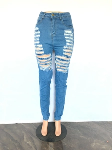 Détail d'un jean bleu clair montrant des trous effilochés et une texture style urbain