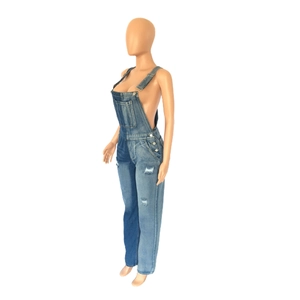 Detail of two-tone denim overalls featuring ripped accents and adjustable straps