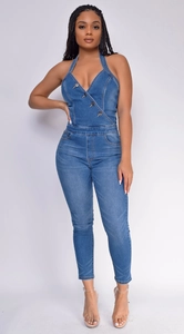 Detail of the slim fit denim halter jumpsuit with a deep V-neck and metal buttons