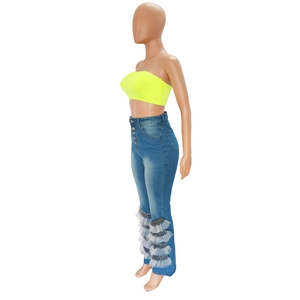 Detail of high-waist flared jeans with metal buttons and layered sheer mesh hem