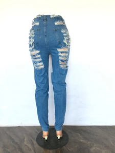 Détail d'un jean skinny bleu taille haute avec découpes déchirées et franges à l'arrière