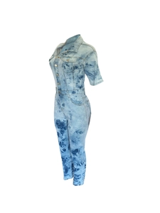 Detail view of women's short sleeve denim jumpsuit with acid wash finish and buttons
