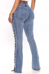 Detailed view of lace-up side design and frayed edges on high waist light blue flare jeans