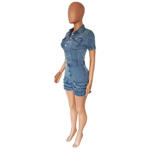 Close-up of blue denim romper featuring metal buttons and layered frayed ruffle hem