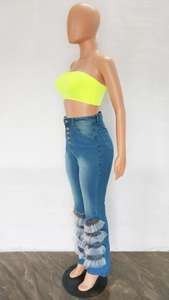 Detail of high waisted blue jeans with multi-button closure and tiered mesh ruffle hem