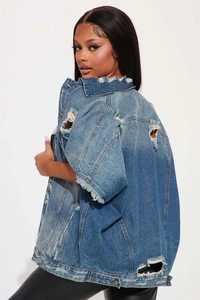 Détails de veste en jean délavée avec déchirures usées et texture vintage authentique