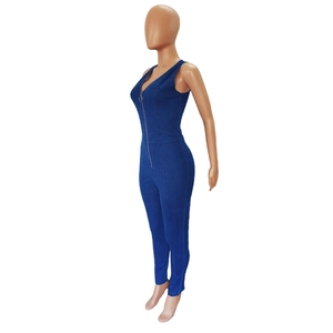 Detail of dark blue denim jumpsuit showing metal zipper and slim fit waist stitching