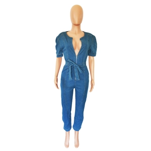 Détail d'une combinaison en jean avec manches bouffantes, zip frontal et ceinture nouée