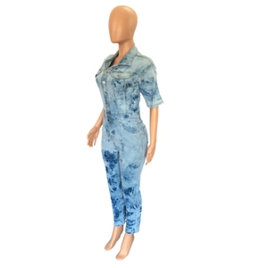 Detail view of tie-dye denim jumpsuit with short sleeves and metal button closure