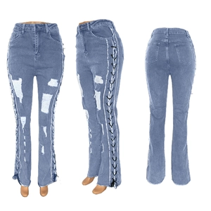 Detail view of high waist skinny jeans with side metal eyelet lace-up and ripped effects
