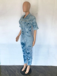 Detail of light blue tie-dye denim jumpsuit with turn-down collar and button closure