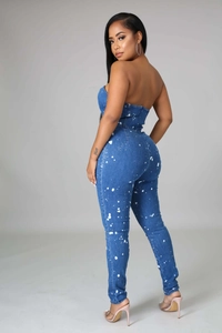 Detail view of the slim-fit strapless denim jumpsuit with white paint splatter effect