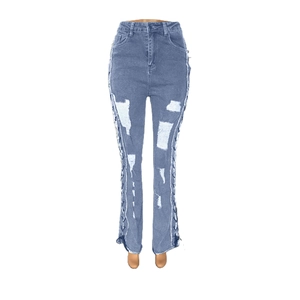 Detail of high-waist ripped jeans with lace-up side design and washed blue finish