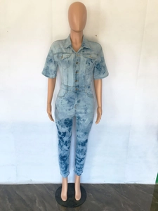 Detail of short sleeve denim jumpsuit with acid wash finish and metallic buttons