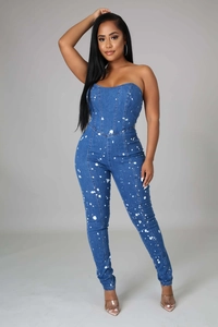 Detail of slim fit strapless denim jumpsuit featuring white artistic paint splatter design
