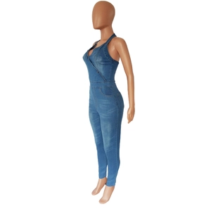 Close-up of slim-fit denim jumpsuit with halter neck and deep V-neckline on brown mannequin