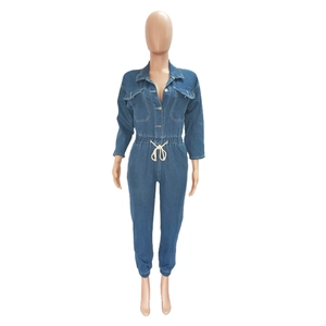 Detail of blue denim jumpsuit featuring a white drawstring waist and chest pockets