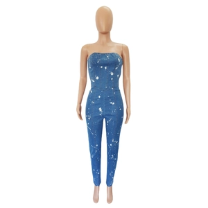 Detail of strapless denim jumpsuit featuring white paint splatter and slim fit cut