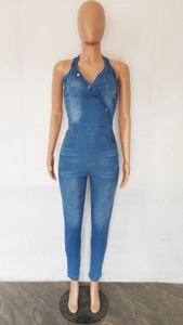 Detail view of denim halter neck jumpsuit with metal buttons and slim fit leg design