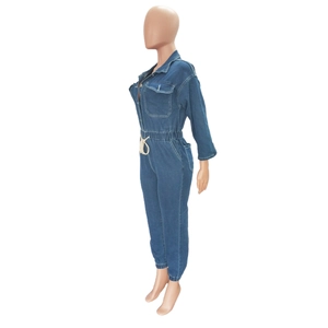 Detail view of denim jumpsuit showing lapel collar, chest pockets and white drawstring waist