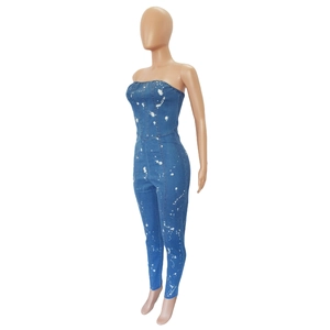 Detailed side view of strapless denim jumpsuit featuring artistic white paint splatter design