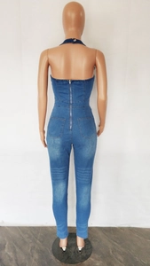 Detail of slim-fit denim jumpsuit featuring back zipper closure and rear pockets