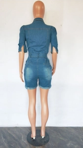 Rear view of slim fit dark blue denim jumpsuit featuring high waist and rolled hems
