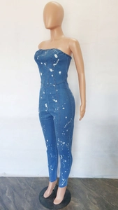Detail view of slim fit denim jumpsuit featuring white splatter print and tube top design
