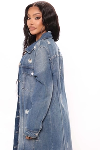 Detailed view of mid-blue distressed denim jacket showing frayed rips and metal buttons