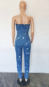Detail view of slim fit tube top denim jumpsuit featuring white splatter print on deep blue
