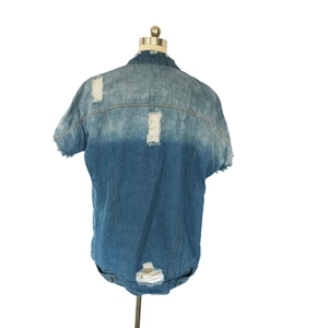 Détail des effets déchirés sur une veste en jean vintage avec lavage dégradé