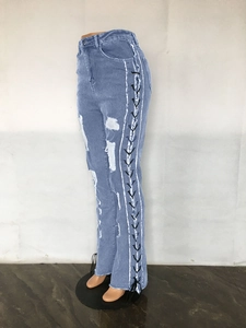 Detail view of high waist distressed blue jeans with side lace-up eyelet design