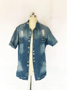 Détails d'une veste en jean vintage délavée avec bords effilochés et éléments usés