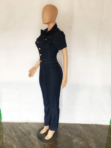 Vue latérale d'une combinaison en jean bleu marine avec boutons métalliques dorés et col à revers