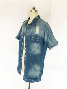 Détail d'une veste en jean bleue à manches courtes avec accents vintage et déchirures