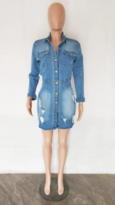 Détail d'une robe en jean bleue avec ourlet déchiré usé et boutons à simple rangée