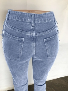 Close-up of high waist skinny jeans back featuring dual pockets and distressed frayed edges
