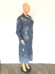 Detail of ripped and distressed denim trench coat showing washed fabric texture