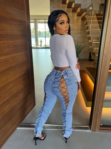 Détail du jean évasé bleu clair avec un design unique à lacets croisés à l'arrière des jambes