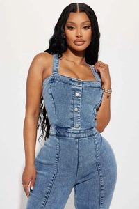 Close-up of blue washed denim jumpsuit featuring metallic front buttons and slim bodice