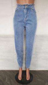 Détail du jean bleu clair taille haute avec taille à bords francs et bouton métallique